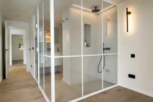 Baño con ducha de obra y mampara de cristal