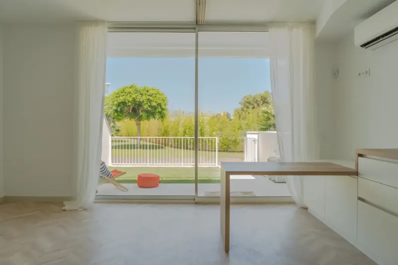 Salón con ventanal al jardín en una vivienda de The Sunset Ibiza, Cala de Bou